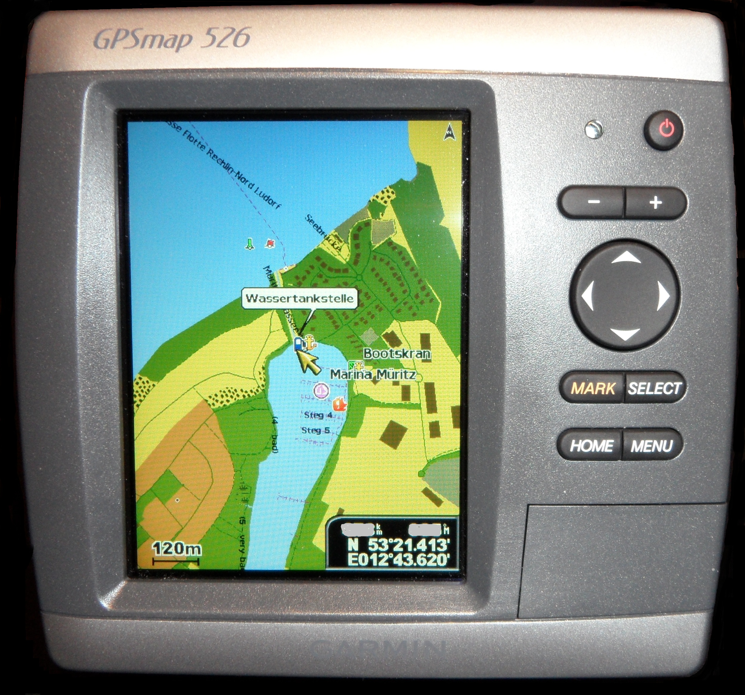 A Garmin chartplotter mounted at a boat helm displaying chart data