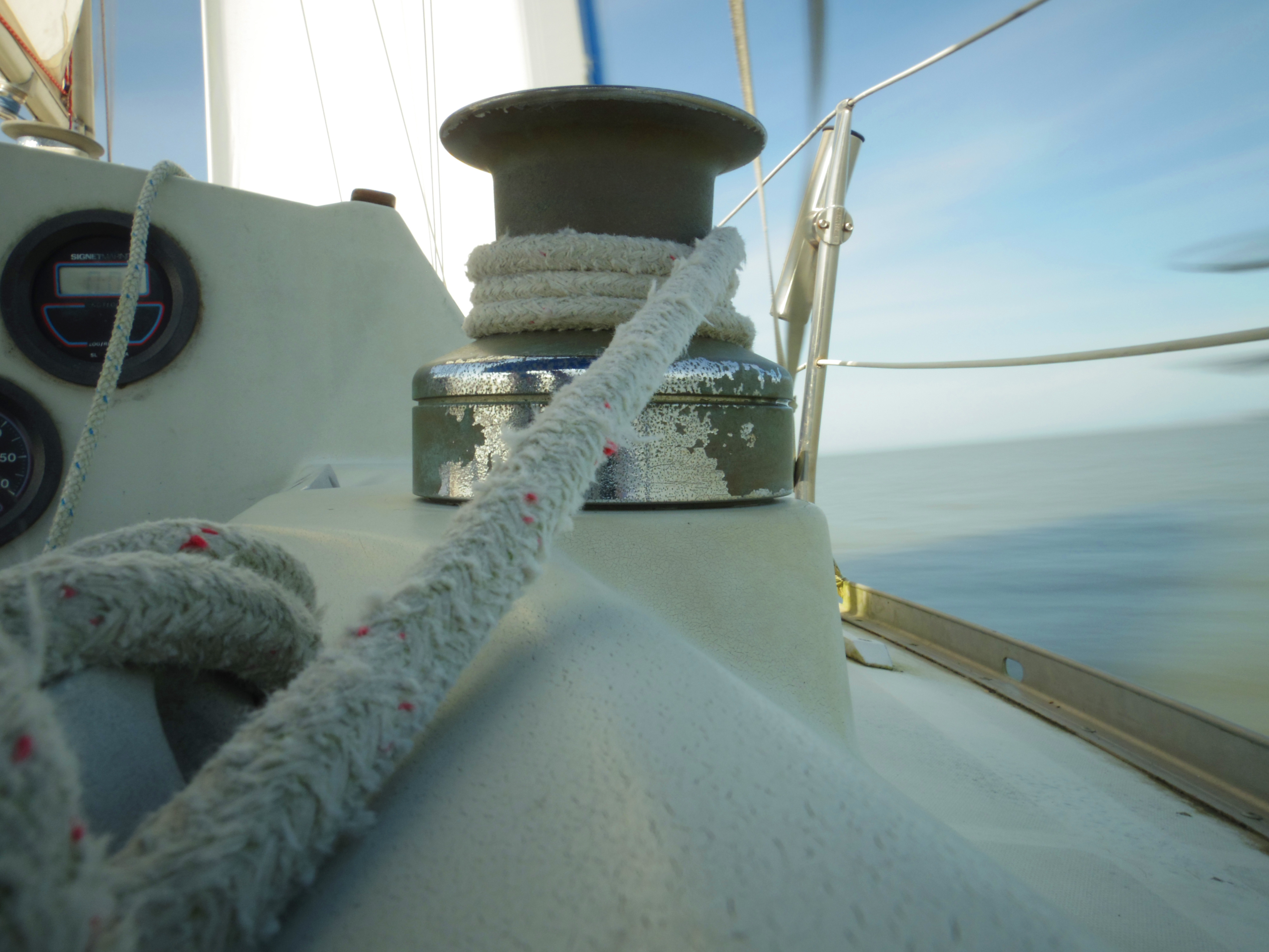 A self-tailing sailboat winch with a sheet loaded on the drum in the cockpit
