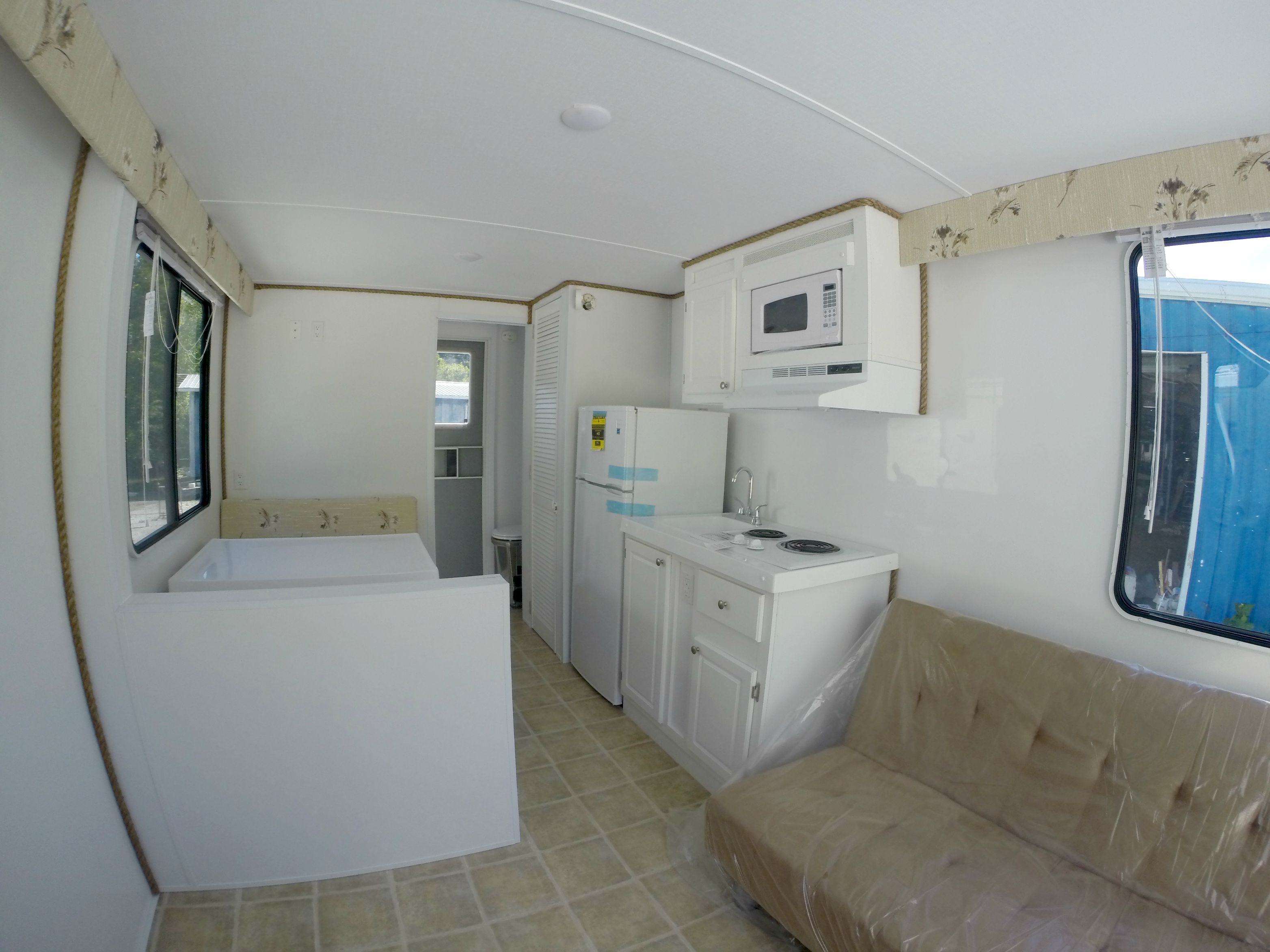 The interior galley of a small cruising sailboat showing a compact stove and cooking area